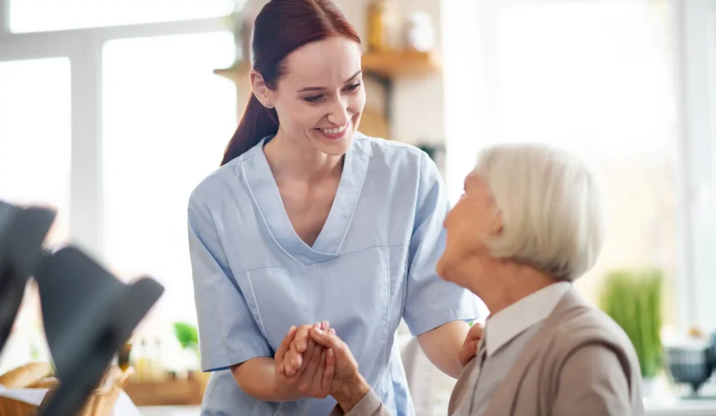 caregiver smiling and talking to aged woman